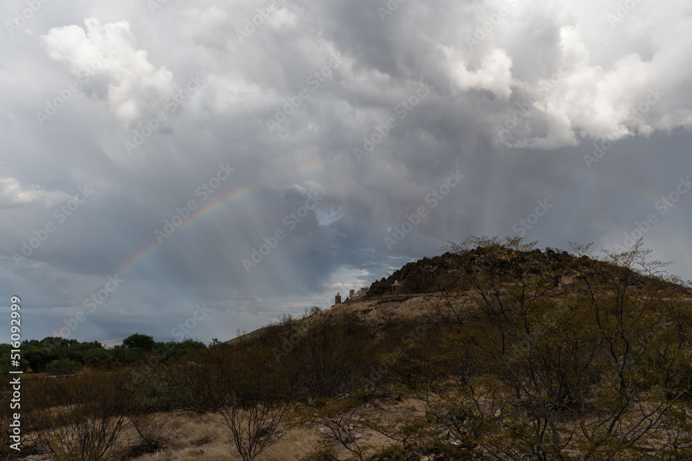 Dramatic sky and rainbow in Tucson, Arizona, near Mission San Xavier del Bac during monsoonal rainstorm Dramatic sky and rainbow in Tucson, Arizona, near Mission San Xavier del Bac during monsoonal rainstorm