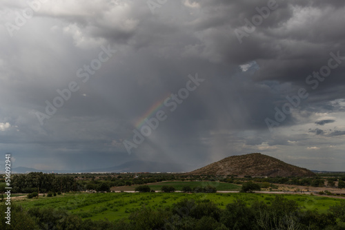 Dramatic sky and rainbow in Tucson, Arizona, near Mission San Xavier del Bac during monsoon season
