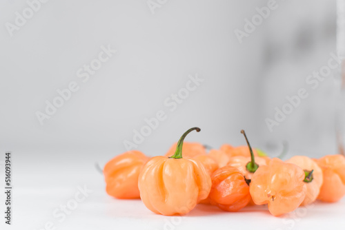 A scotch bonnet pepper with stem on a white background, fresh pepper, orange coral pepper, Nigerian scotch bonnet pepper