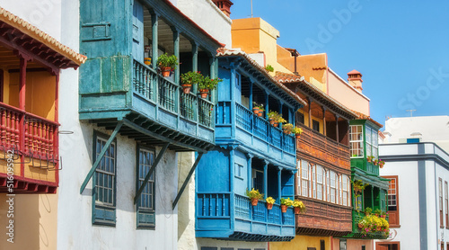 Fototapeta Naklejka Na Ścianę i Meble -  Old buildings in a city built by traditional architecture in a small town or village. Home or flats with a vintage design close to each other outdoors with a blue sky in Santa Cruz de La Palma