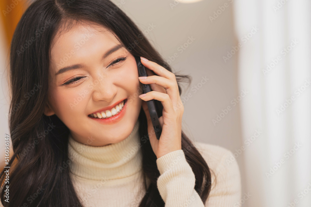 Phone conversation. Confident Asian woman sit on couch talk speak communicate by telephone from home holding device at ear. Phone conversation. Confident Asian woman sit on couch talk speak communicate by telephone from home holding device at ear.