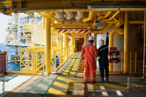 Canvas Print Male workers inspect long steel pipes and pipe elbows in oil and gas stations between oil and gas pipelines recorded with a digital camera