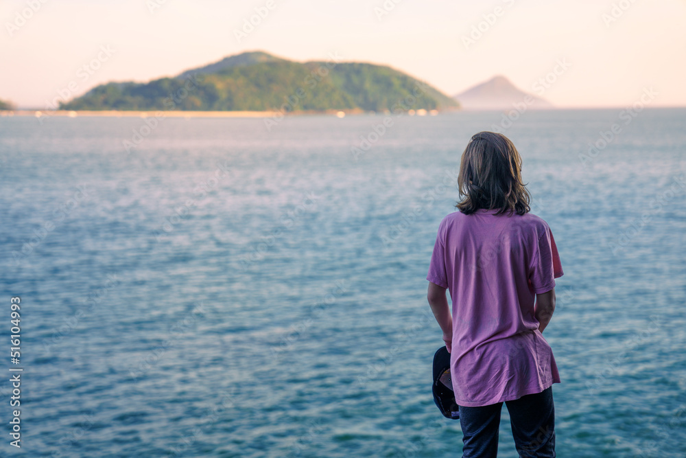 Garoto admirando a linda paisagem do Mar no litoral brasileiro