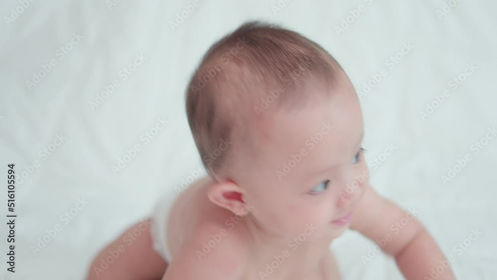 Close-up of face cute asian newborn baby. while playing and crawling on white bed look at camera with laughing smile happy face. Innocent little new infant adorable. Parenthood and Mother Day concept Close-up of face cute asian newborn baby. while playing and crawling on white bed look at camera with laughing smile happy face. Innocent little new infant adorable. Parenthood and Mother Day concept
