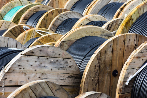 Wooden Coils Of Electric Cable Outdoor. High and low voltage cables in the storage.