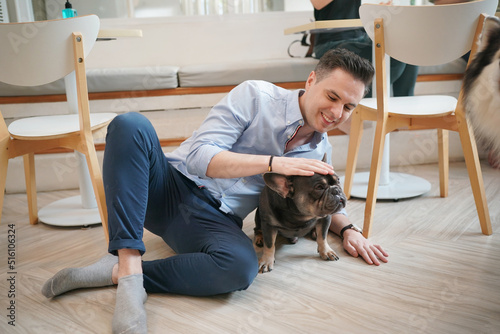 Man petting french bulldog on carpet in living room