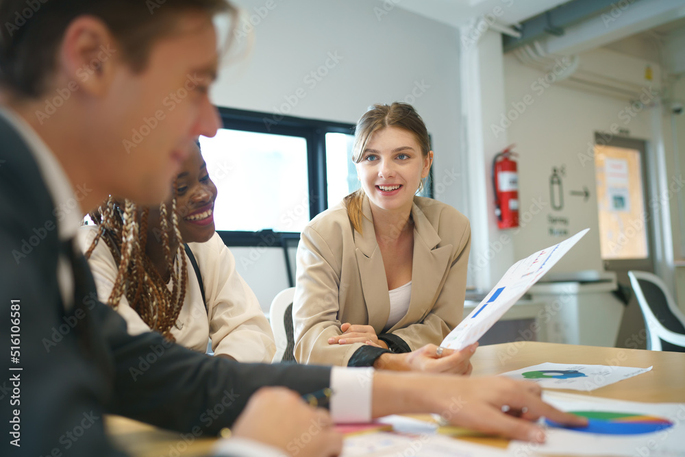 Obraz premium Image of young business people discussing document in paperwork data on desk at meeting