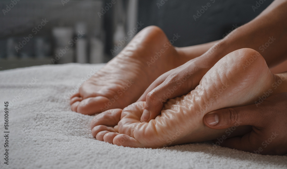 Fototapeta premium Woman Foot spa massage treatment by professional massage therapist in spa resort. Wellness, stress relief and rejuvenation concept. Body care