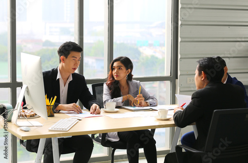 Group of young modern people in smart casual wear communicating and using modern technologies while working in the office © FotoArtist