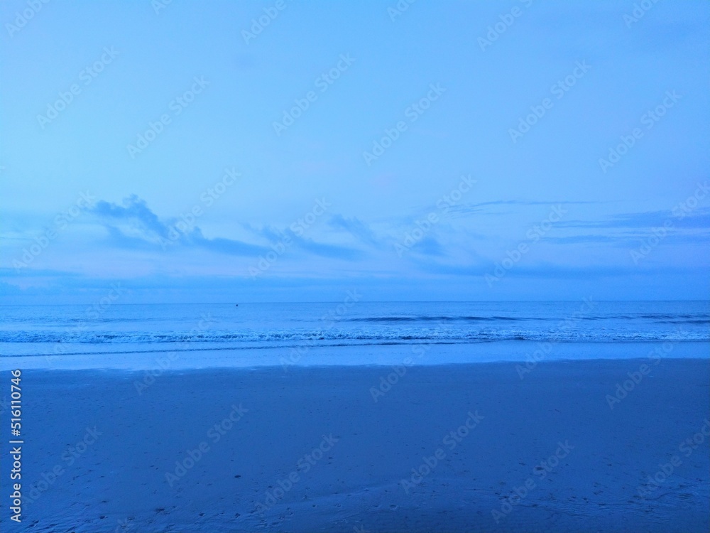 Soft Blue Early Morning Beach Waves and Clouds