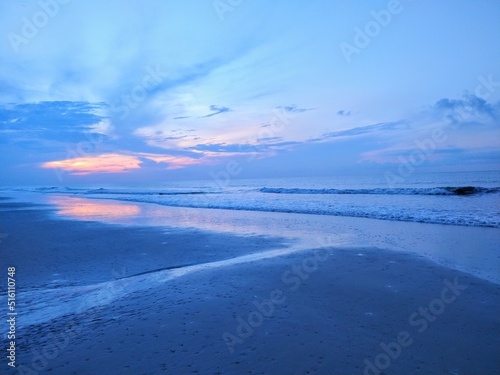Blue Beach Ocean Sunrise and Streaming Water Into Shore