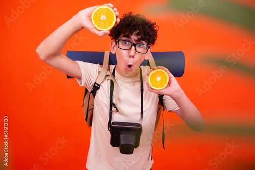 Fototapeta Young attractive tourist with a backpack. Orange background.