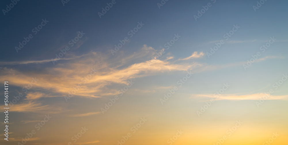 Colorful sunset sky background in the evening with orange sunlight clouds on blue sky, dusk