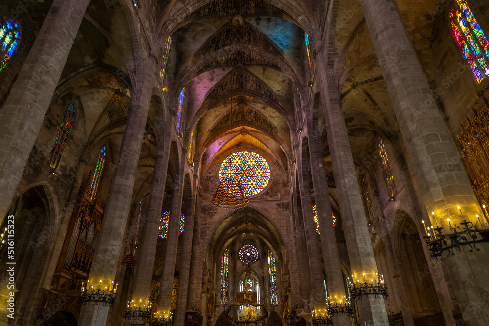 The ornate gothic interior with stained glass windows and imposing columns in the Palma de Santa Maria Cathedral of Palma, or La Seu, in the Mediterranean city of Palma de Mallorca Spain.