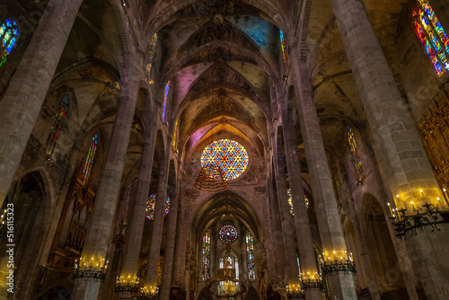 The ornate gothic interior with stained glass windows and imposing columns in the Palma de Santa Maria Cathedral of Palma, or La Seu, in the Mediterranean city of Palma de Mallorca Spain.