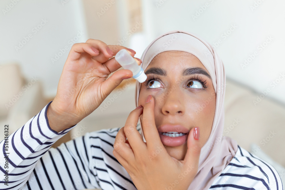 Stockfoto Arabic woman with hijab using eye drop, dropping eye