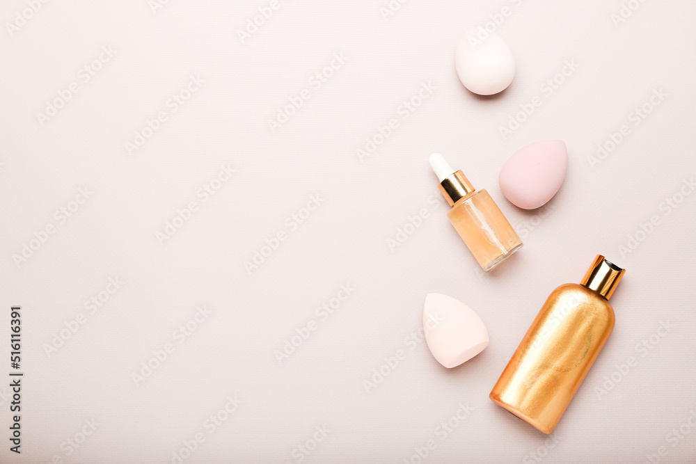 Obraz premium makeup sponges and cosmetics on a beige background. Beauty concept, top view, space for text