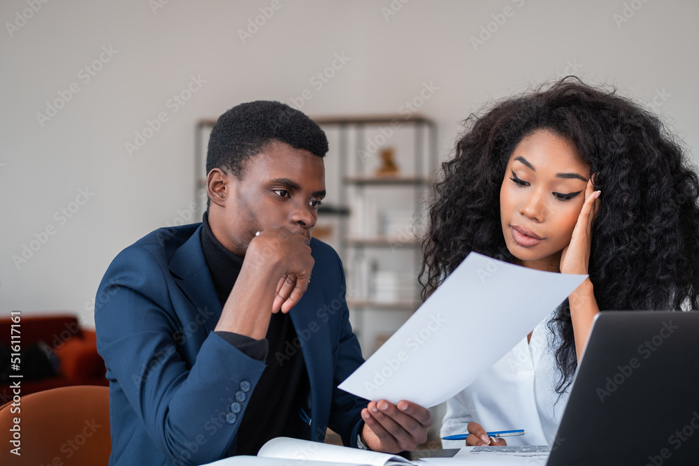 African business people working together, studying papers with pensive look African business people working together, studying papers with pensive look