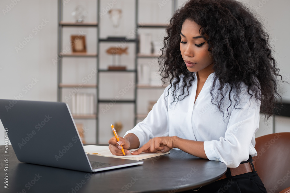Black businesswoman take note, working in modern office room Black businesswoman take note, working in modern office room
