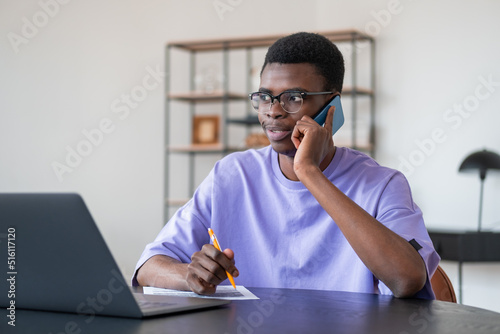 Black businessman talk on the phone, laptop and contract on desk in office room