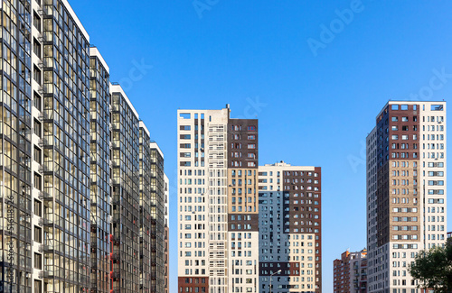 Monolithic residential apartment block buildings district on blue sky 