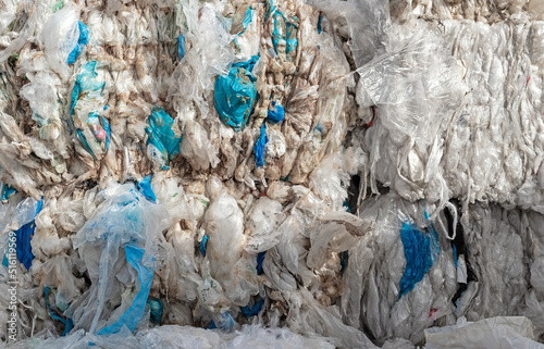 Close-up of a pile of compressed plastic waste at a waste recycling plant photo