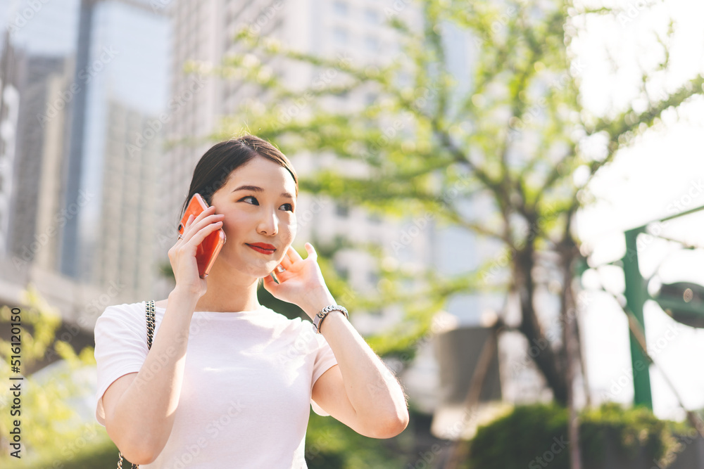 Happy young adult asian business single woman use mobile phone talking with friend city background. Happy young adult asian business single woman use mobile phone talking with friend city background.