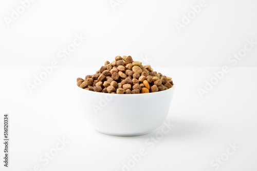 Food for cats and dogs in a white bowl on a white background.
