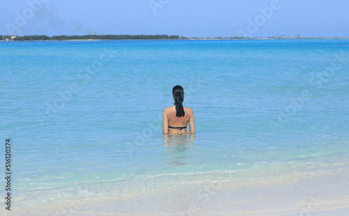 girl model in a black bikini swims in the ocean