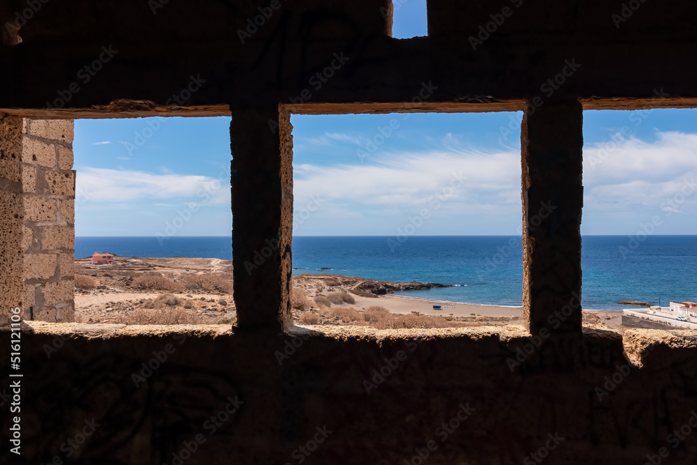 Panoramic sea view through windows on Abades beach from the interior of concrete church of abandoned leper village of Sanatorio de Abona near Abades beach, east coast of Tenerife Spain. Ghost town