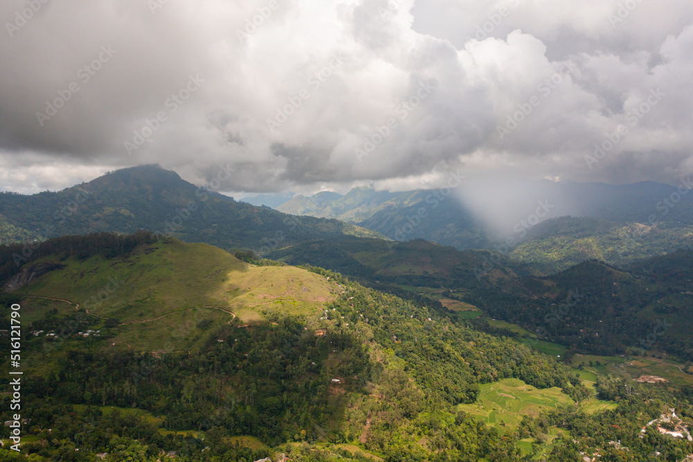 Obraz premium Mountain slopes with rainforest and agricultural land of farmers. Sri Lanka.