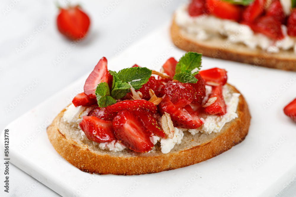 Toast with strawberry, cottage cheese, ricotta cheese, honey, almond and mint. Sweet strawberry dessert. Sandwich, Bruschetta, snack, appetizers with strawberry.