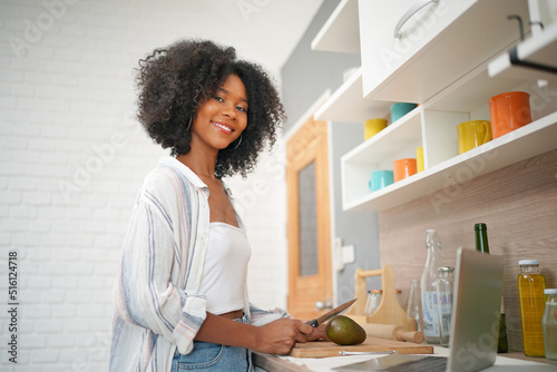 Portrait of an attractive young woman using laptop at home. African american woman working on laptop computer at a home on freelance concept.