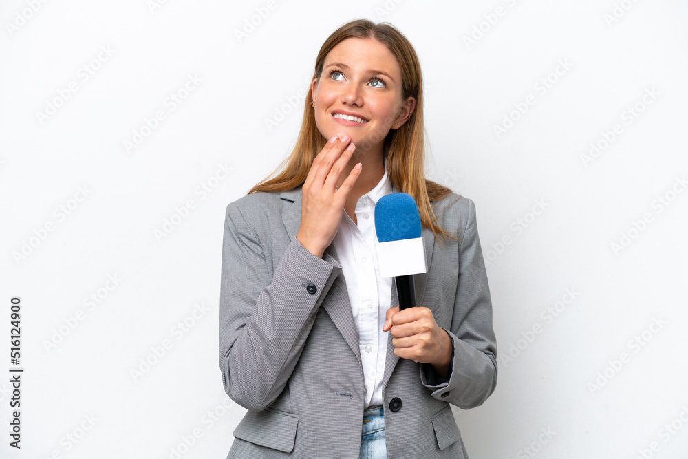 Young caucasian tv presenter woman isolated on white background looking up while smiling Young caucasian tv presenter woman isolated on white background looking up while smiling