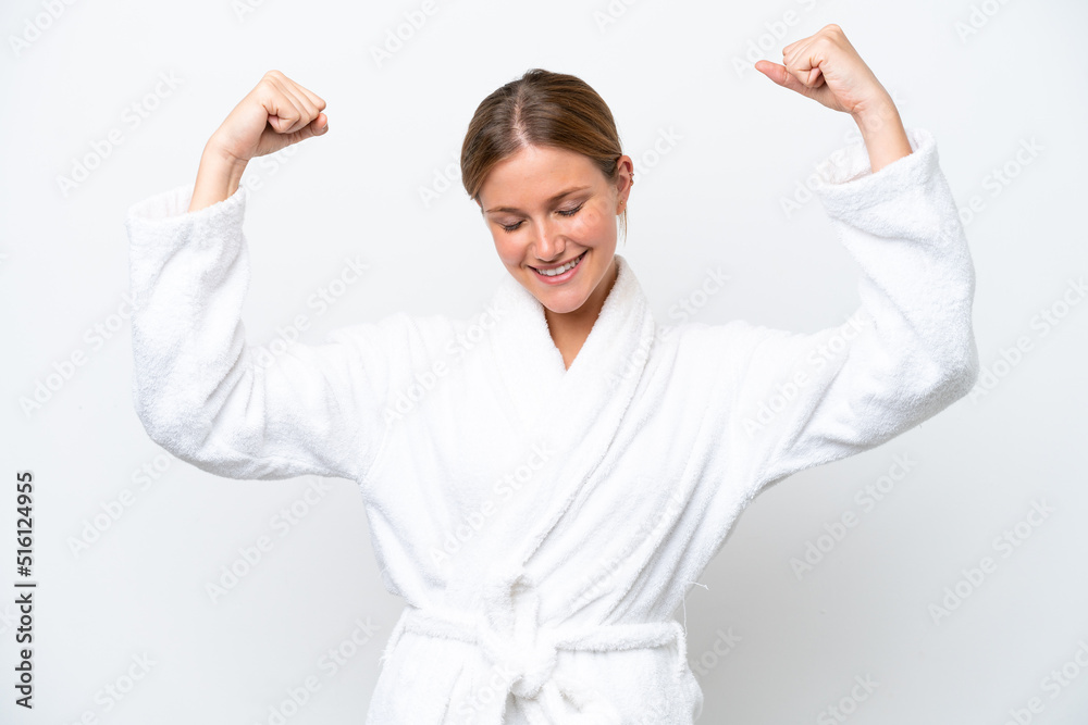 Young pretty blonde woman in bathrobe isolated on white background doing strong gesture Young pretty blonde woman in bathrobe isolated on white background doing strong gesture
