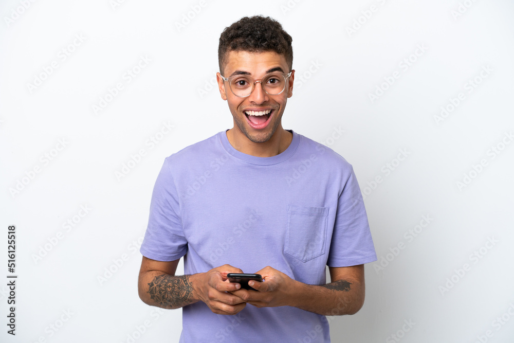 Young caucasian Brazilian man isolated on white background surprised and sending a message