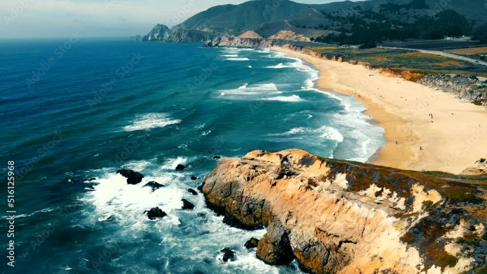 Montara State Beach in California. Aerial Flying over a beautiful beach with a rocky shore and ocean waves coming to the shore. A beautiful landscape of the coast line that is not far from San