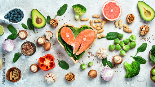 Foods good for the heart: nuts, salmon, avocados, spinach, mushrooms, berries. On a stone background. Top view.