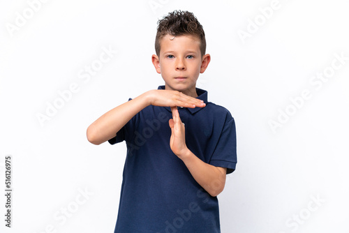 Little caucasian boy isolated on white background making time out gesture
