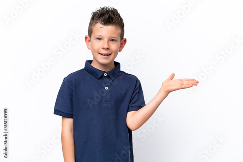 Little caucasian boy isolated on white background holding copyspace imaginary on the palm to insert an ad
