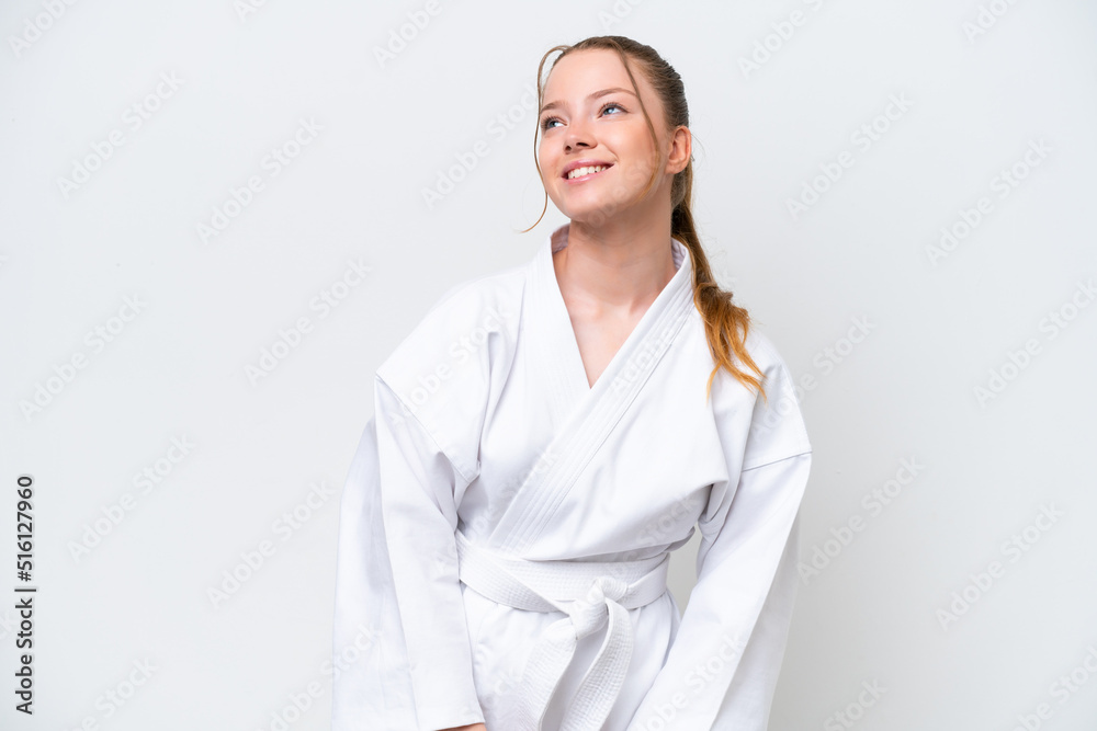Young caucasian girl doing karate isolated on white background thinking an idea while looking up Young caucasian girl doing karate isolated on white background thinking an idea while looking up