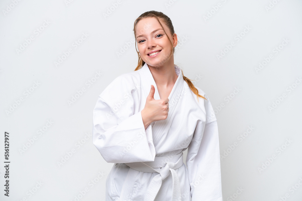 Young caucasian girl doing karate isolated on white background giving a thumbs up gesture Young caucasian girl doing karate isolated on white background giving a thumbs up gesture