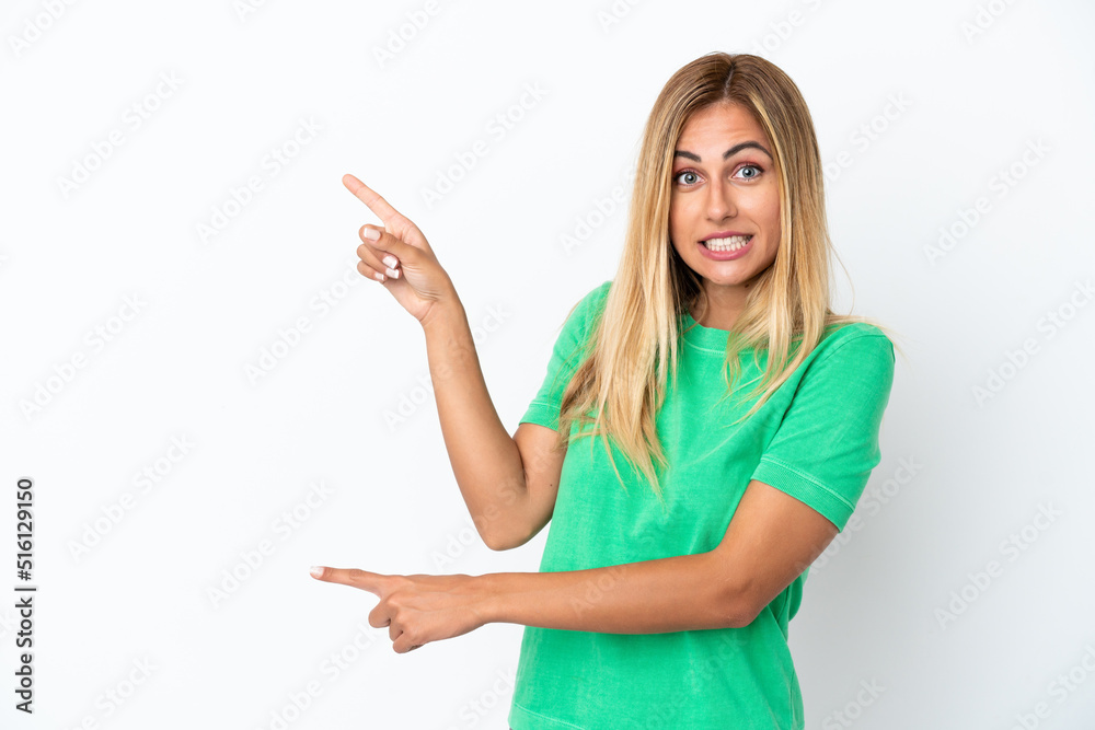 Blonde Uruguayan girl isolated on white background frightened and pointing to the side Blonde Uruguayan girl isolated on white background frightened and pointing to the side