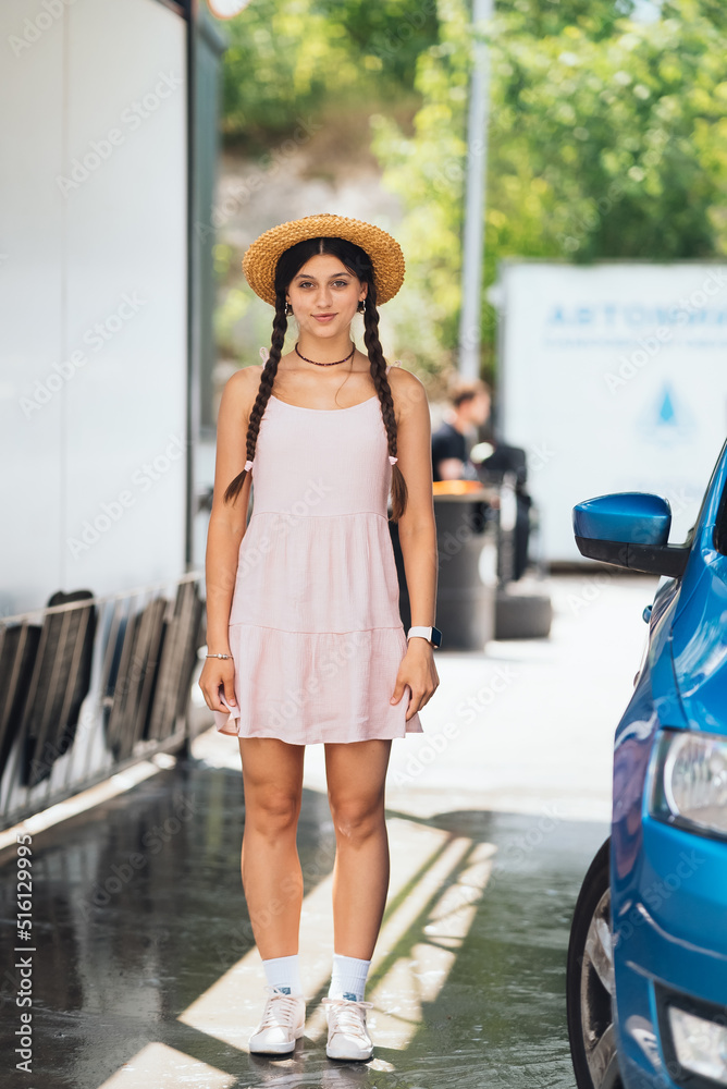 Beautiful young woman in a short dress at car wash