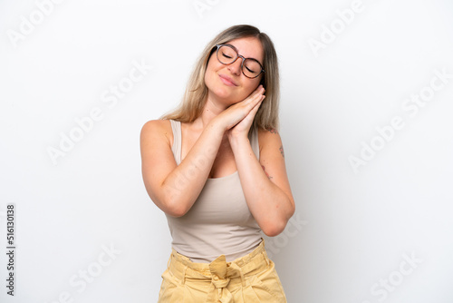 Young Rumanian woman isolated on white background making sleep gesture in dorable expression