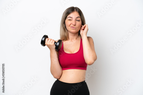 Young sport Rumanian woman making weightlifting isolated on white background frustrated and covering ears