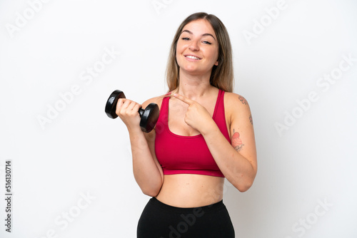 Young sport Rumanian woman making weightlifting isolated on white background pointing to the side to present a product