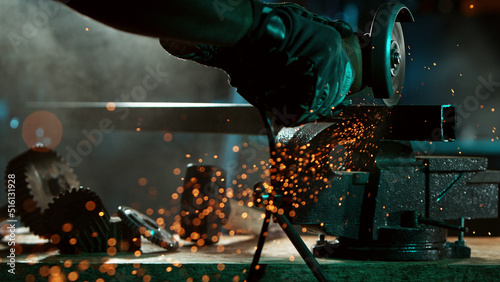 Fotografie Detail of industry worker cutting steel pipe with flex saw