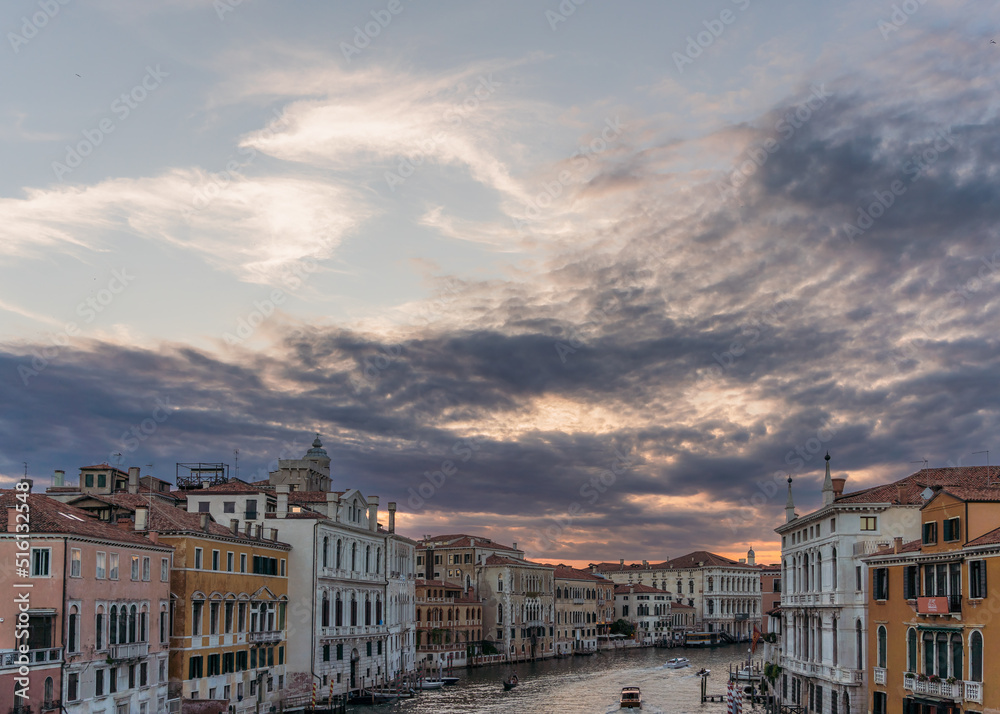 Incredible sunset, clouds and traditional venetian architecture seen from the grand canal in Venice, Italy