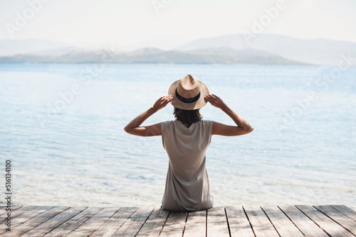 Young woman enjoying life at vacation. Pretty girl looking at the sea on vacation. Relaxation, vacations, travel lifestyle, summer fun, enjoying life concept